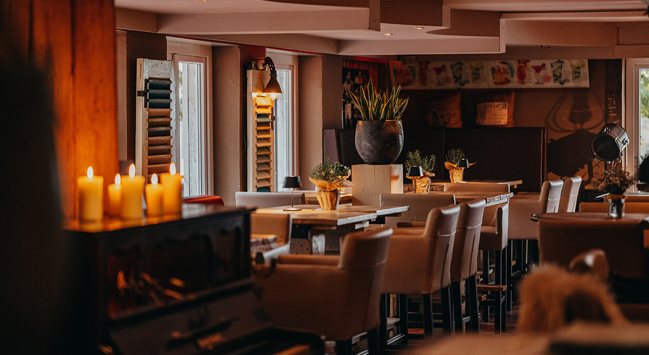 Restaurant_Foto_Location Das Restaurant in gemütlicher Abendstunde mit Kerzenschein auf dem Klavier.